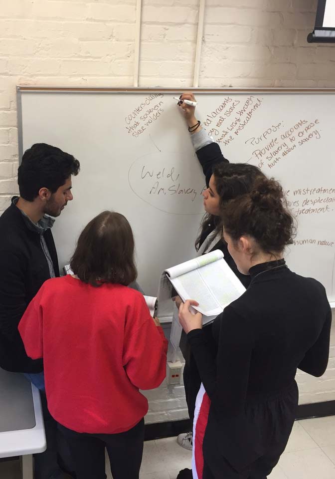Group of Carillon students gather around whiteboard during discussion